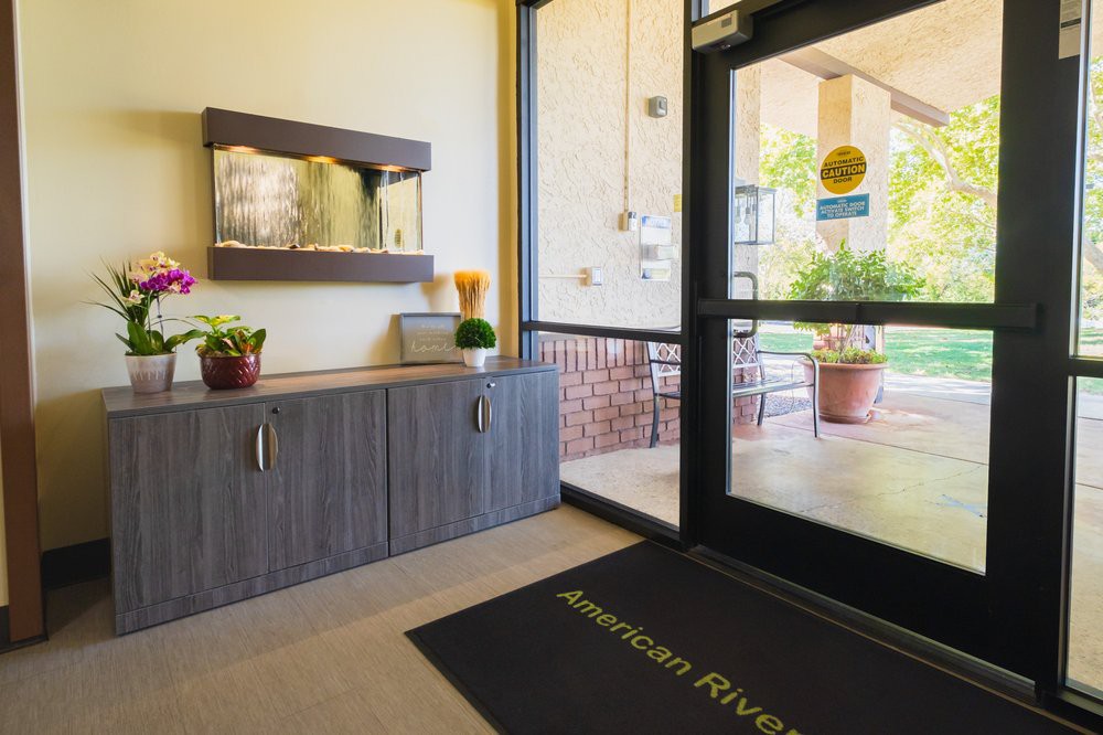 A welcoming entrance area with a door mat, plants, and decorative elements.