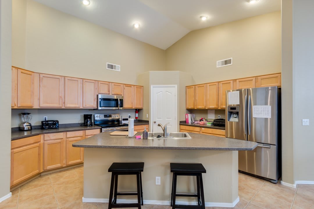 A modern kitchen with a center island and stainless steel appliances.