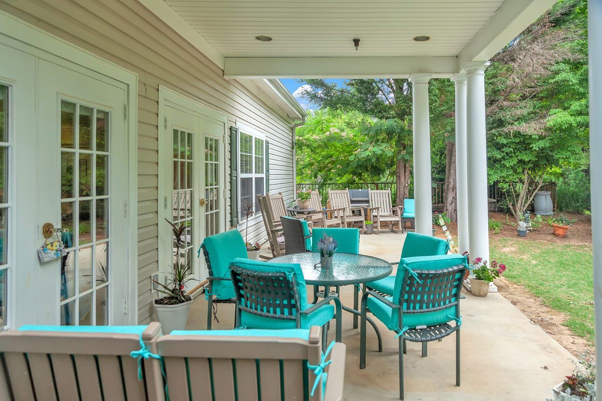 A cozy outdoor patio with turquoise seating and a round table, perfect for relaxing in the backyard.