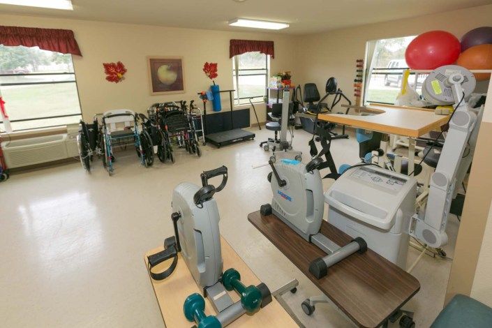 A well-equipped physical therapy room featuring various exercise machines and rehabilitation tools.