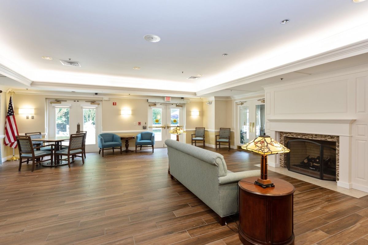 A spacious and well-lit living room with comfortable seating and wooden flooring.
