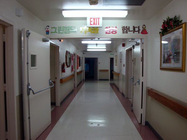 A hospital corridor with exit signs and fluorescent lighting.