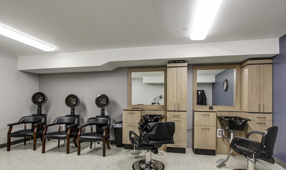 Modern hair salon interior with styling stations and hair dryers.