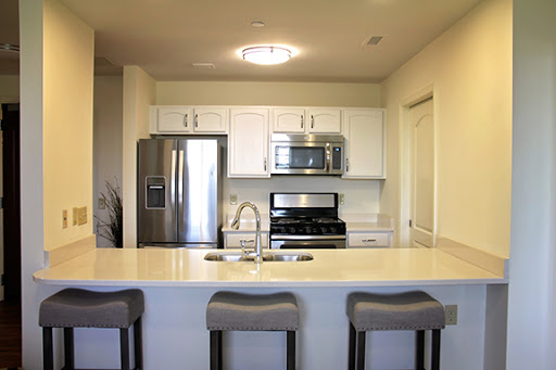 A modern kitchen featuring sleek appliances and a spacious island with bar stools.
