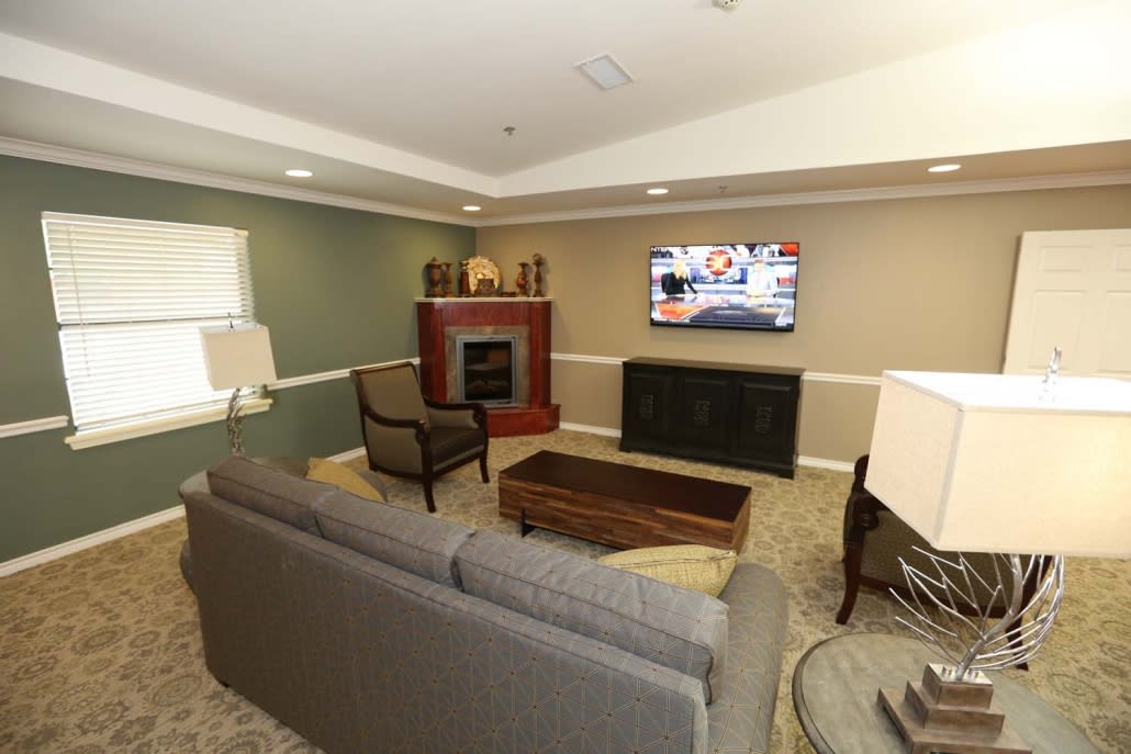 Modern living room with a comfortable sofa, fireplace, and a wall-mounted television.