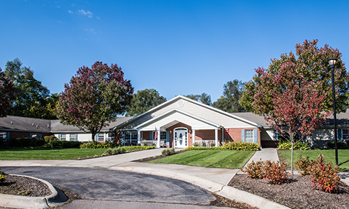 A suburban residential building with a landscaped front yard and driveway.
