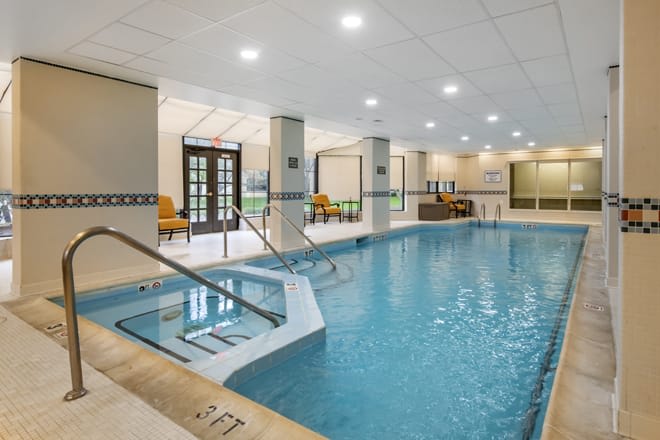 Luxurious indoor swimming pool with seating area.