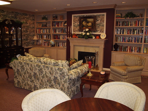 A cozy living room featuring a fireplace, bookshelves filled with books, and comfortable seating.
