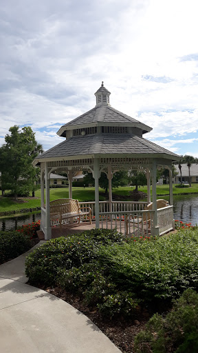 A charming gazebo surrounded by greenery and water, perfect for relaxation.