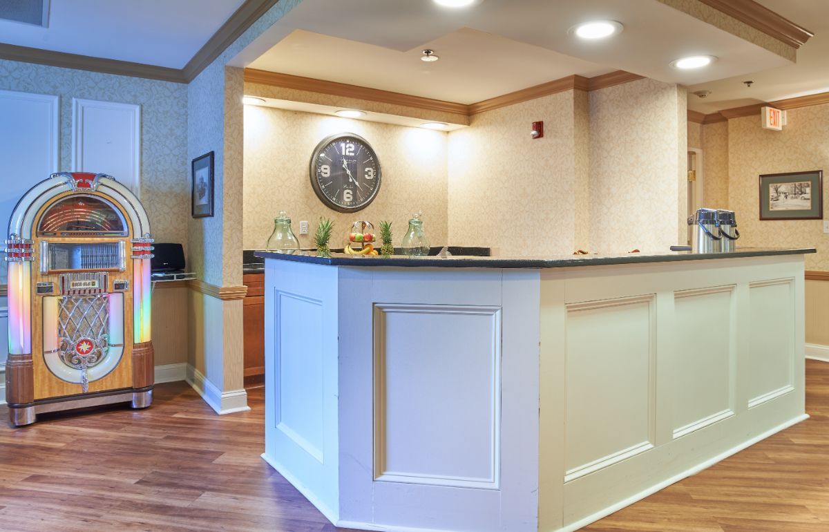 Reception desk area in an office setting with a wall clock and overhead lighting.