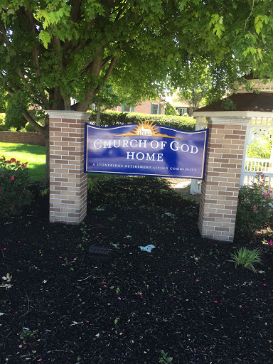 A welcoming sign for the Church of God Home, surrounded by well-maintained landscaping.