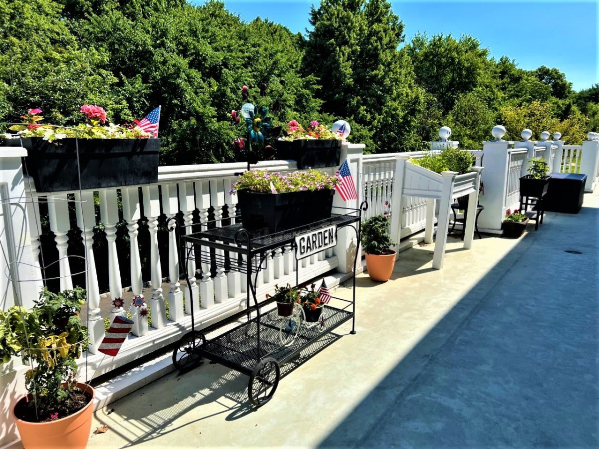 A sunny balcony adorned with potted plants and garden furniture, offering a peaceful outdoor retreat.