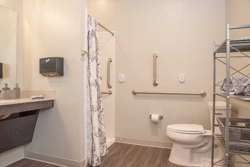 A clean and accessible bathroom featuring a shower, toilet, and sink.