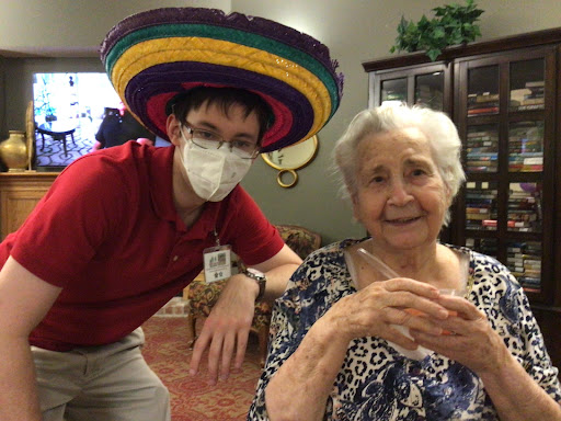 A joyful moment shared between a caregiver and a resident, showcasing a playful spirit.