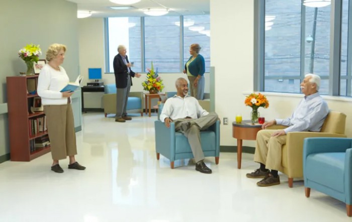 A modern waiting room with people sitting and conversing.