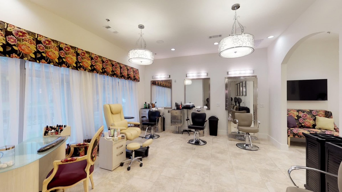 A brightly lit salon interior with styling chairs and mirrors.
