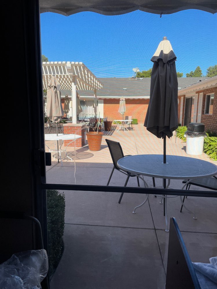 A sunny outdoor patio area with tables and umbrellas.