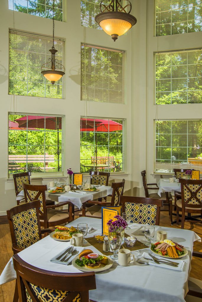 A cozy restaurant dining area with large windows offering a scenic view.