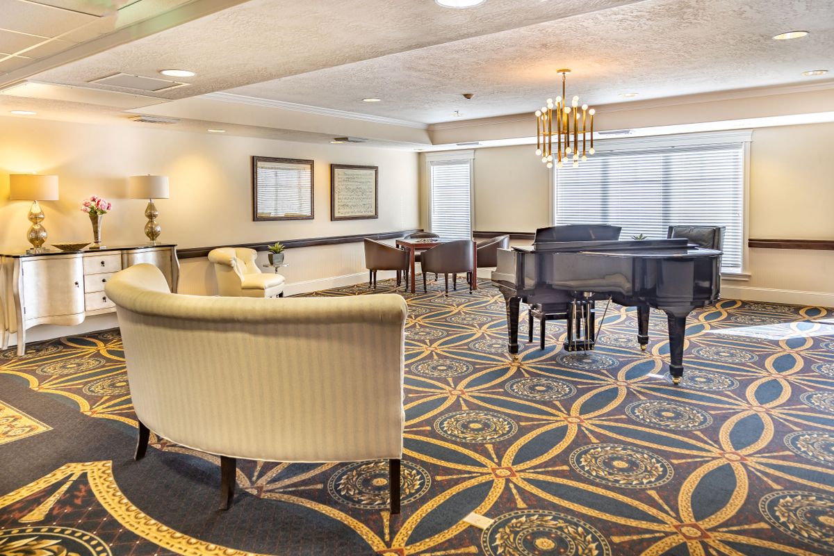 A spacious living room with elegant furniture and a grand piano.
