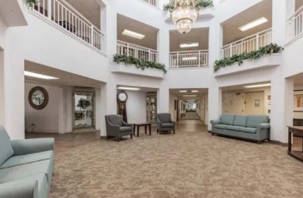 A spacious lobby with elegant furnishings and a large chandelier.
