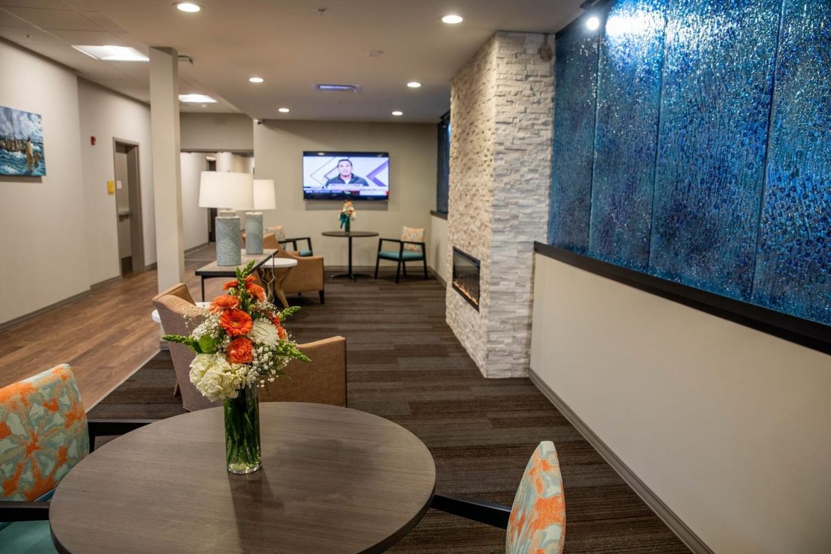 A modern lobby with cozy seating, a fireplace, and stylish decor.