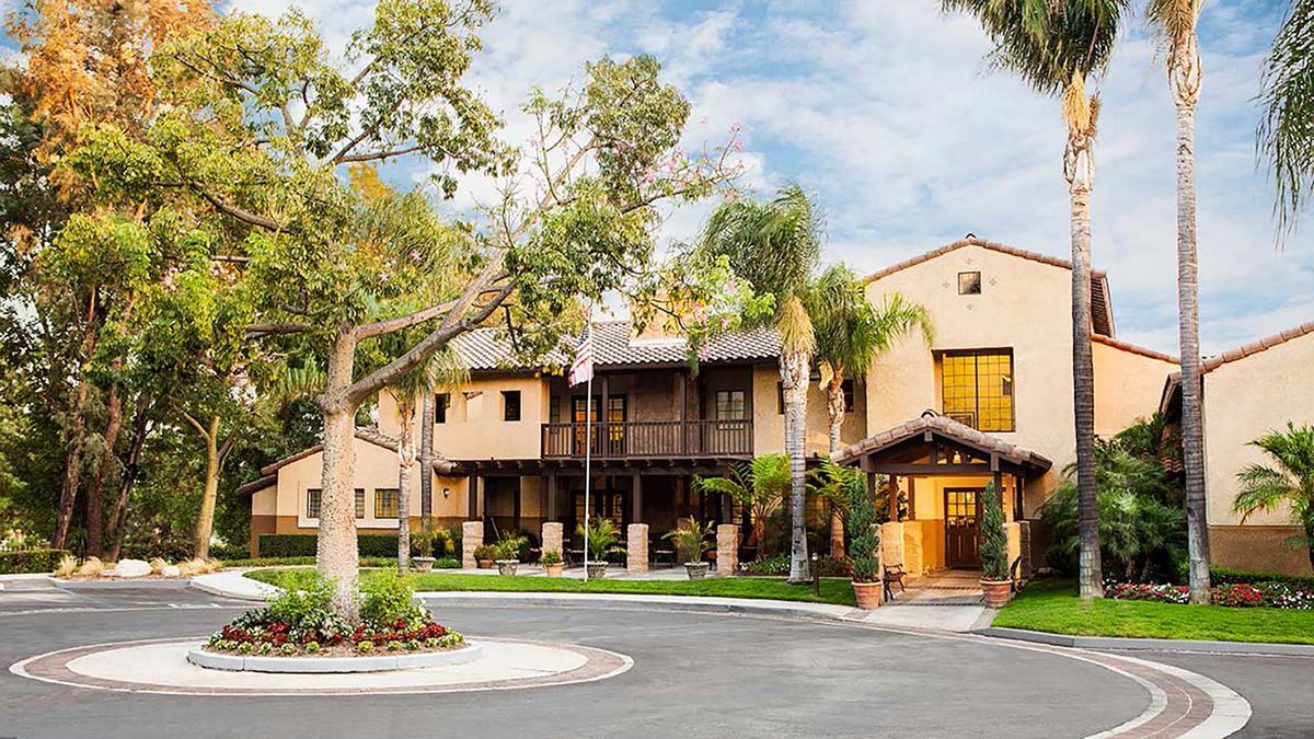 A beautiful residential building with palm trees and well-maintained landscaping.