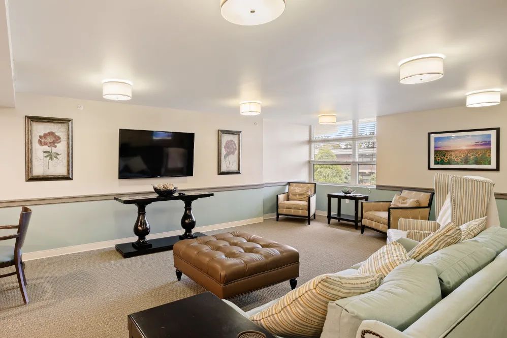 A modern living room with comfortable seating, a wall-mounted television, and stylish lighting.