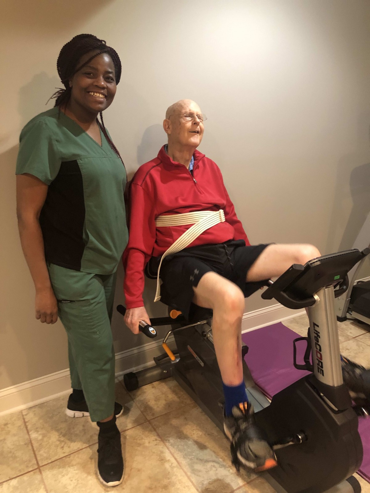 A healthcare worker assisting a senior during an exercise session.
