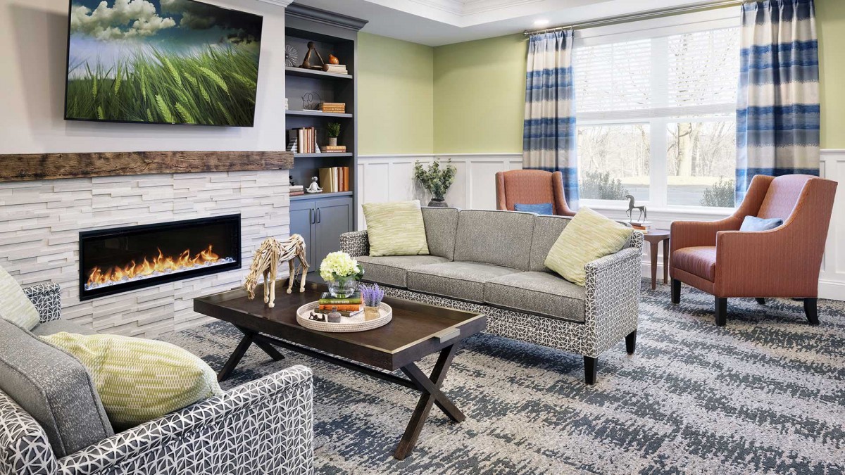A modern living room with a cozy fireplace, stylish furniture, and decorative accents.