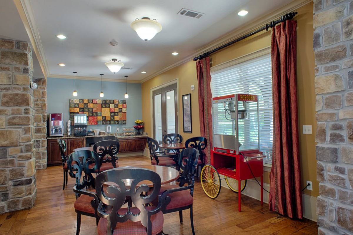 A cozy dining area featuring multiple tables and chairs, complete with a popcorn machine by the window.
