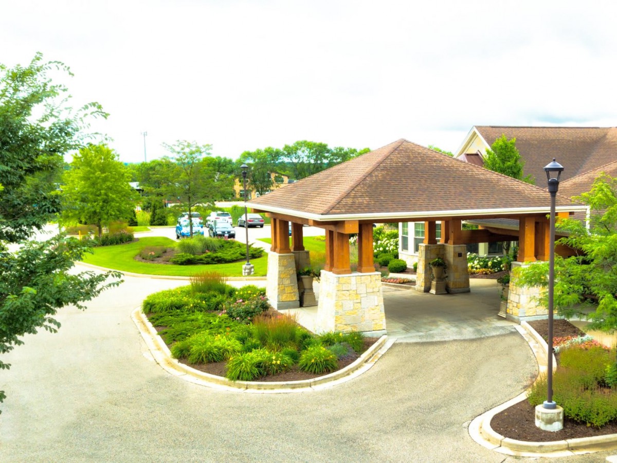 A scenic view of a building entrance surrounded by landscaped greenery.
