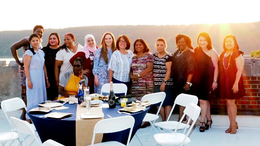 A joyful outdoor gathering of women enjoying a sunset dinner together.