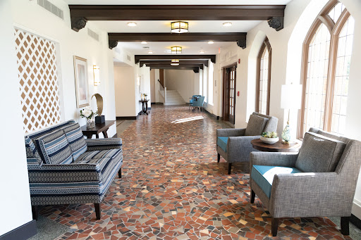 A spacious and elegantly designed hallway featuring comfortable seating and decorative lighting.