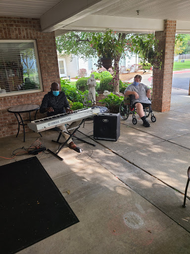 A musician performing on a keyboard outdoors, providing entertainment for residents in a community setting.