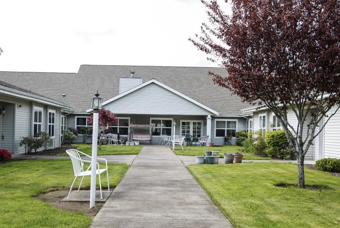 A well-maintained residential building with a garden and pathway leading to the entrance.