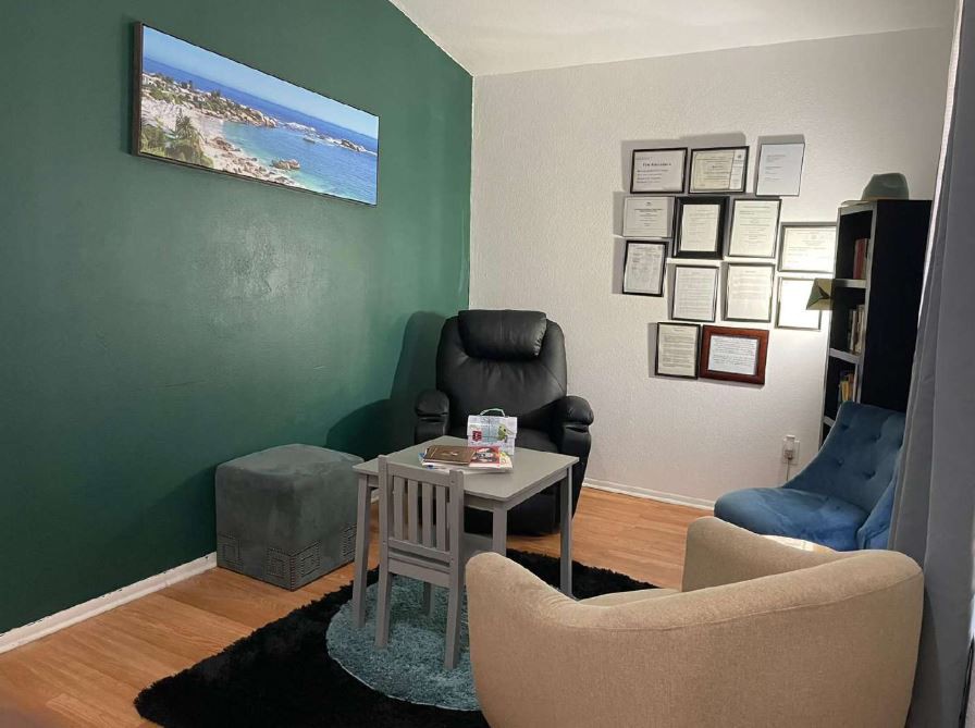 A cozy office space with comfortable seating and certificates displayed on the wall.