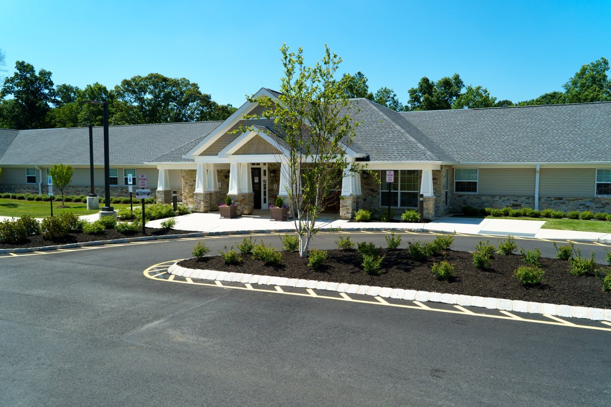 A modern building with a well-landscaped entrance and surrounding greenery.