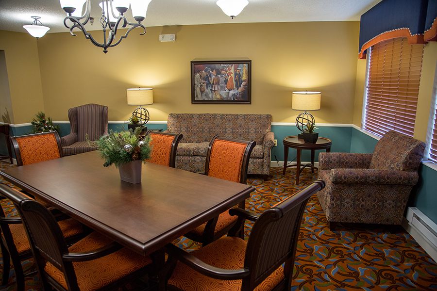 A cozy living room with a dining table and chairs, complete with sofas and warm lighting.