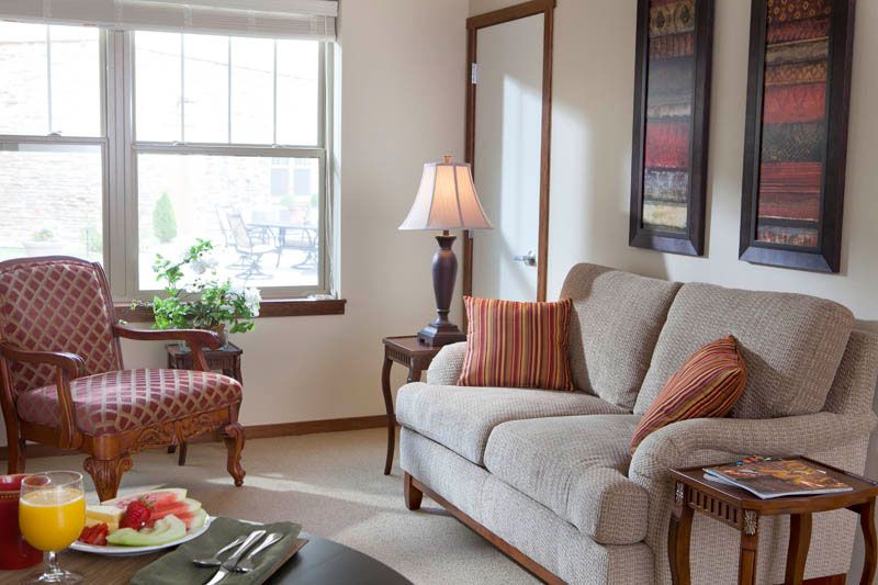 A cozy living room with a sofa, side table, and lamp near a window.