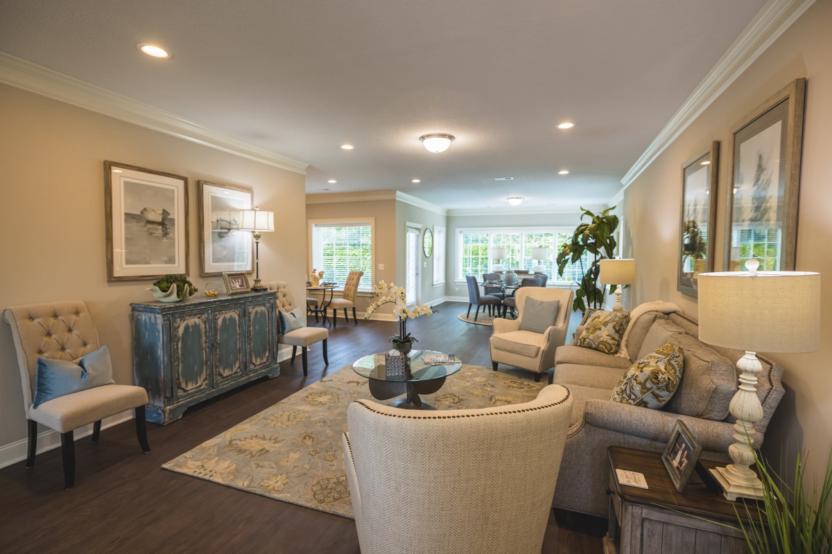 A spacious and elegantly decorated living room with modern furniture and ample natural light.