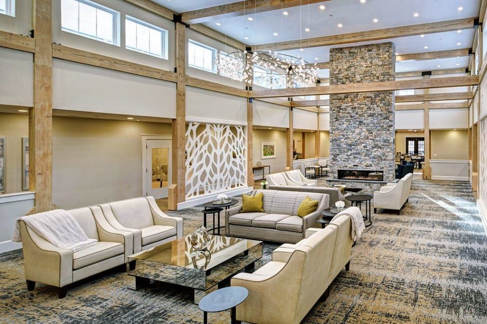 A modern and spacious living room with elegant furniture and a large stone fireplace.