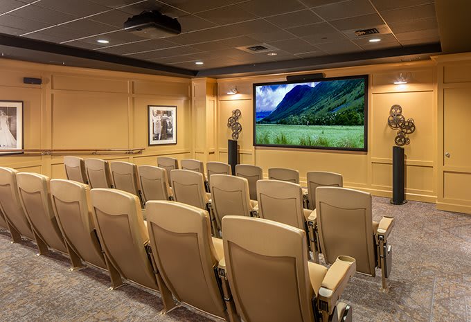 A cozy home theater with multiple rows of seating and a large screen.