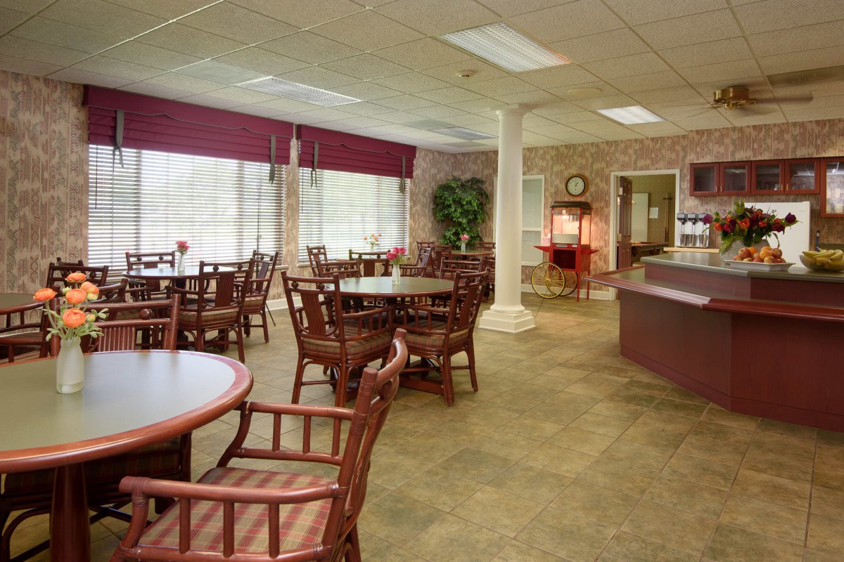 A restaurant dining area with neatly arranged tables and chairs near large windows.