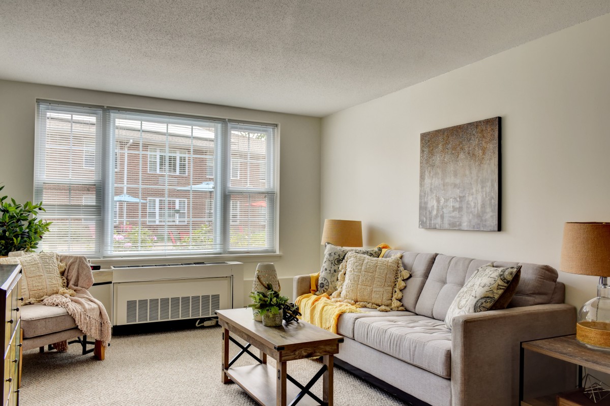 A cozy living room with a comfortable sofa, coffee table, and large window.