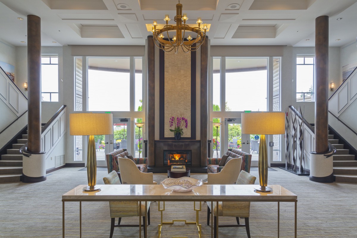 A luxurious lobby featuring elegant lighting, a central seating area, and large windows.