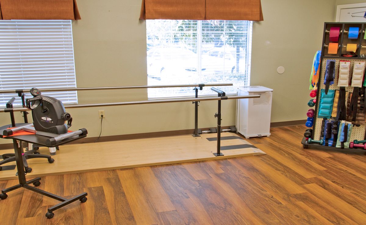 A physical therapy room featuring parallel bars used for rehabilitation exercises.