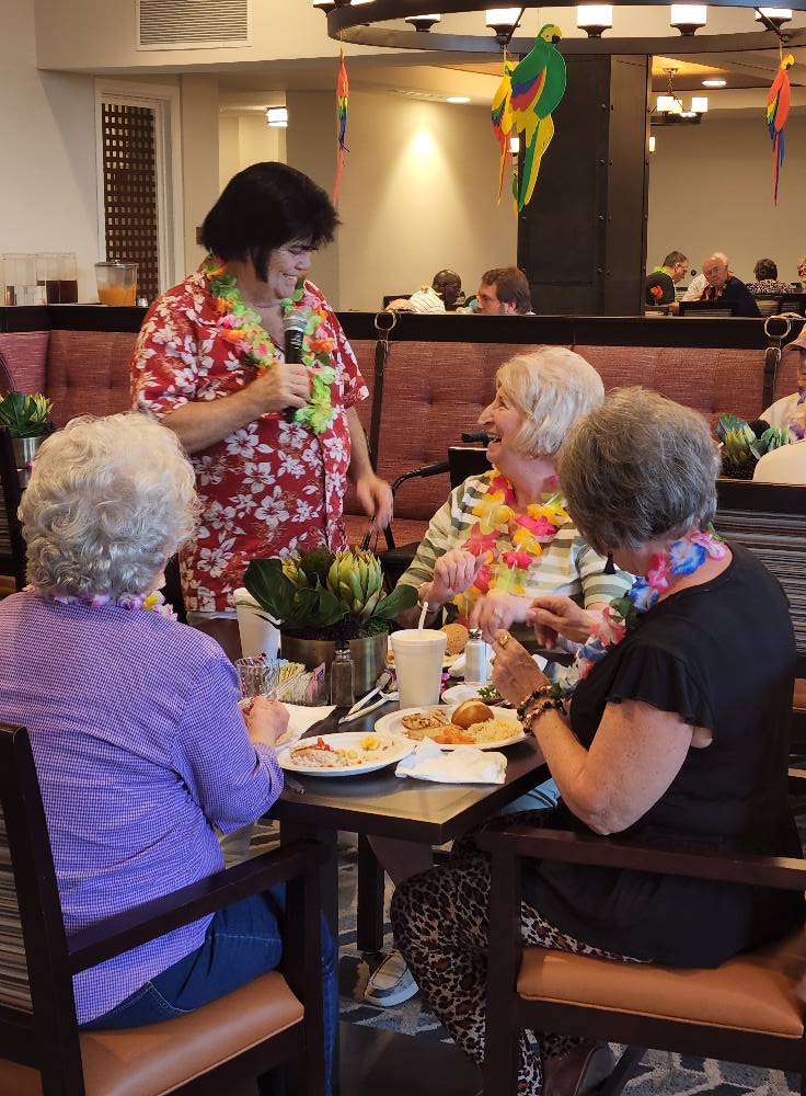 A group of seniors enjoying a meal and conversation at a restaurant.