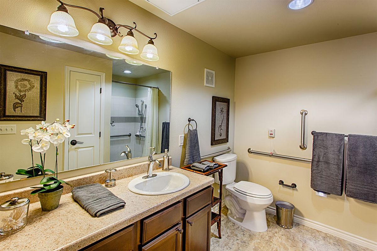 Modern bathroom with a sink, mirror, and well-lit fixtures.