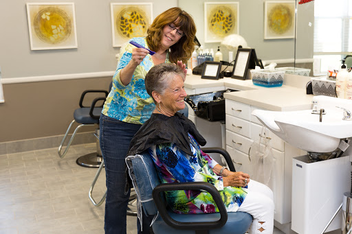A stylist giving a haircut to a client in a modern salon.