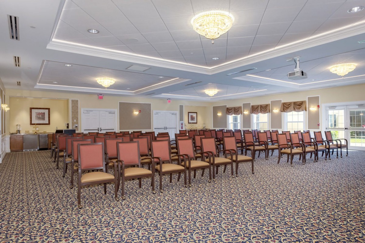 A well-lit conference room with rows of chairs arranged for an event.